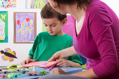 The teacher checks the artwork in the school-1